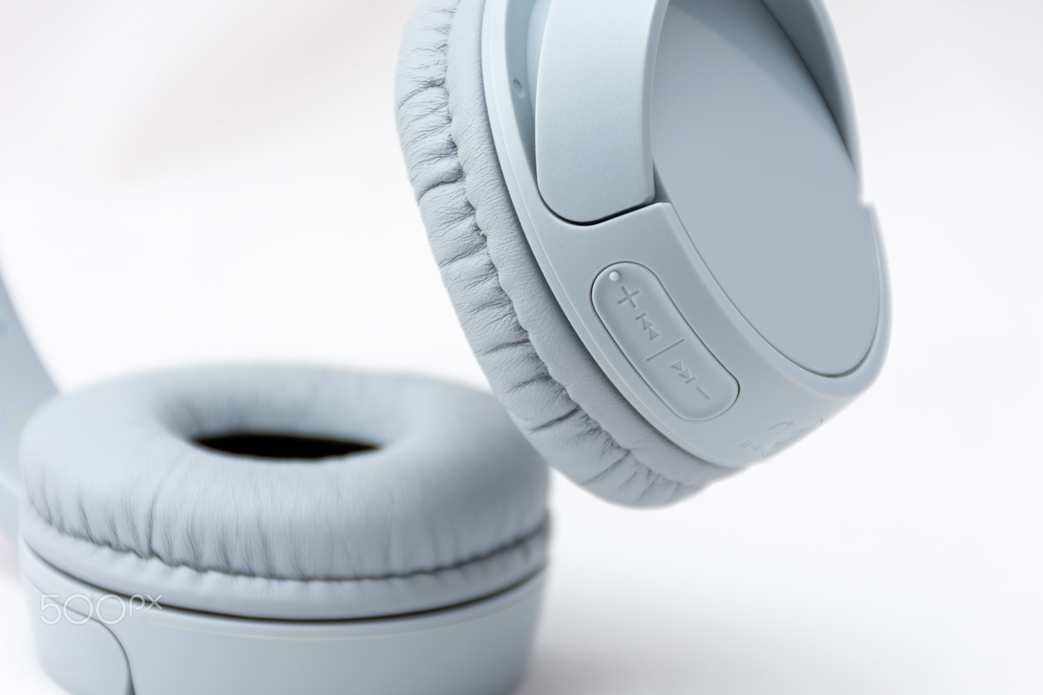 Close-up of gray wireless headphones isolated on white background.