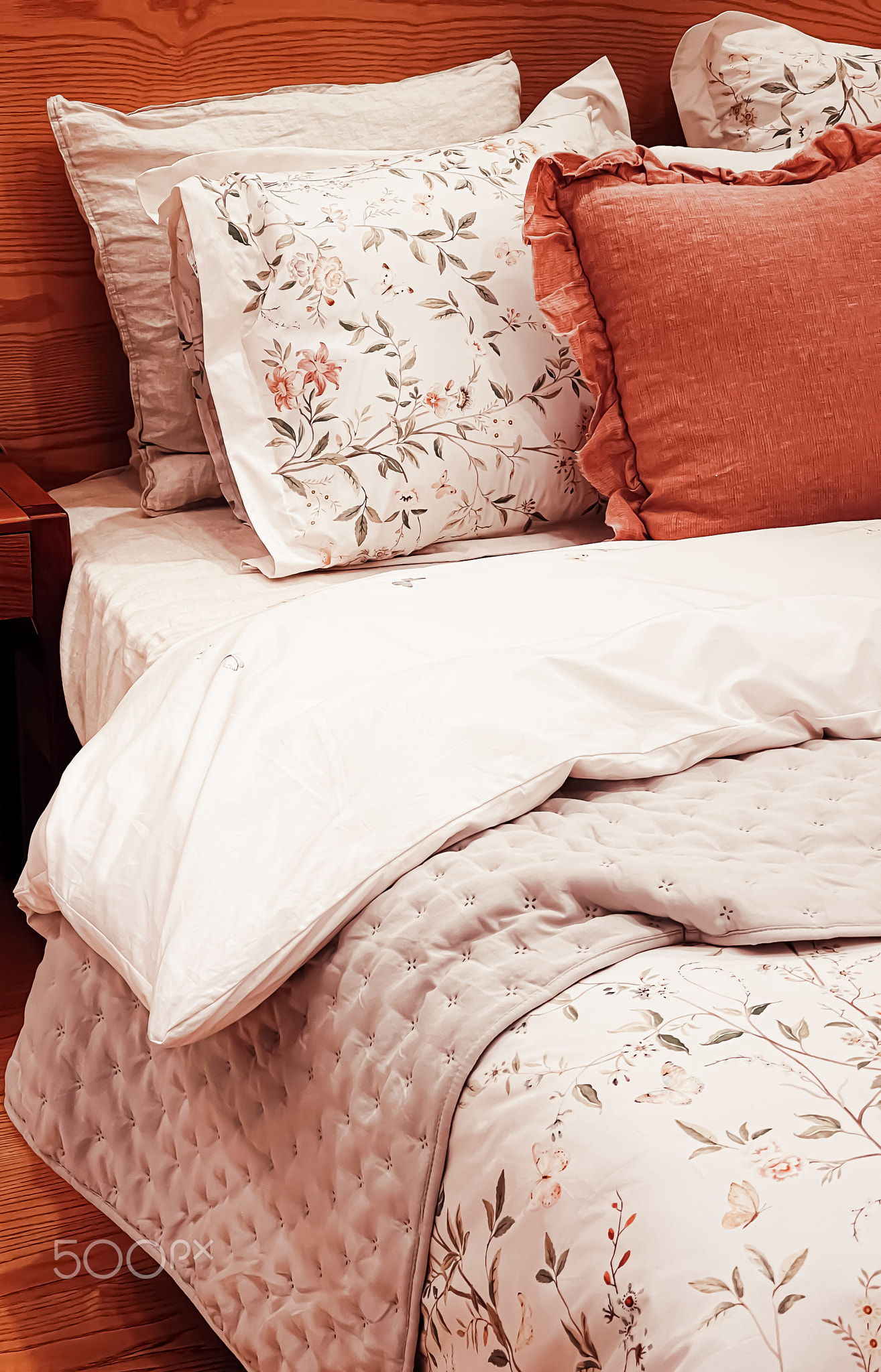 Vintage countryside style bedding with floral pattern on wooden bed in