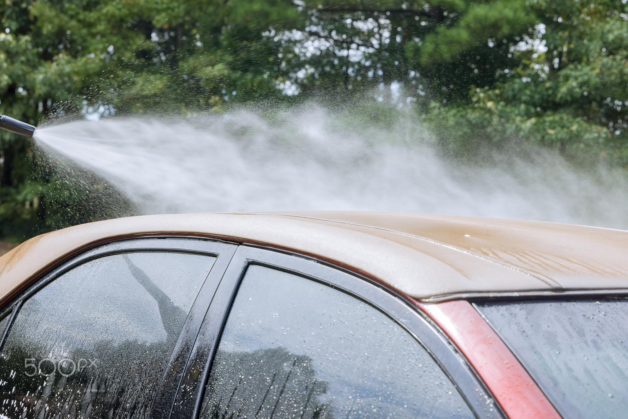 A man cleaning car with washing car under high pressure jet spraying