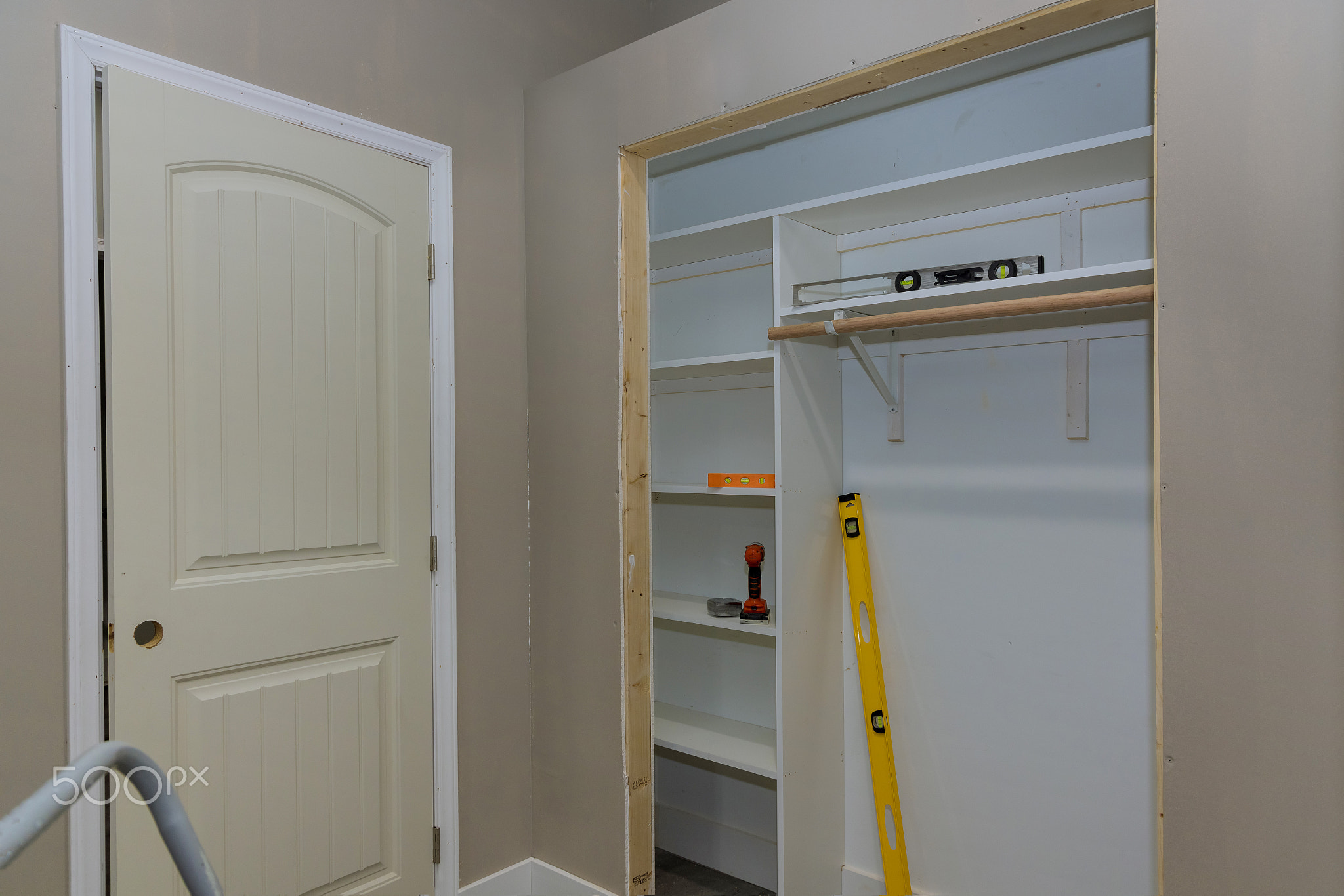 Adding a white melamine shelf to the interior of a clothing closet in