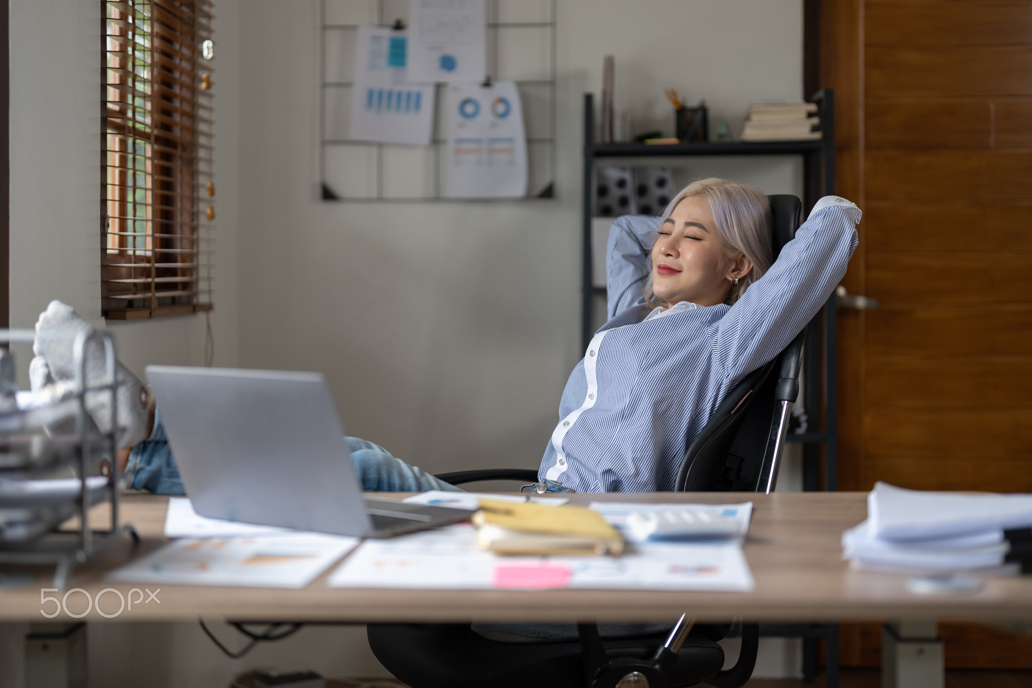 Business asian woman relaxing with hands behind her head and sitting