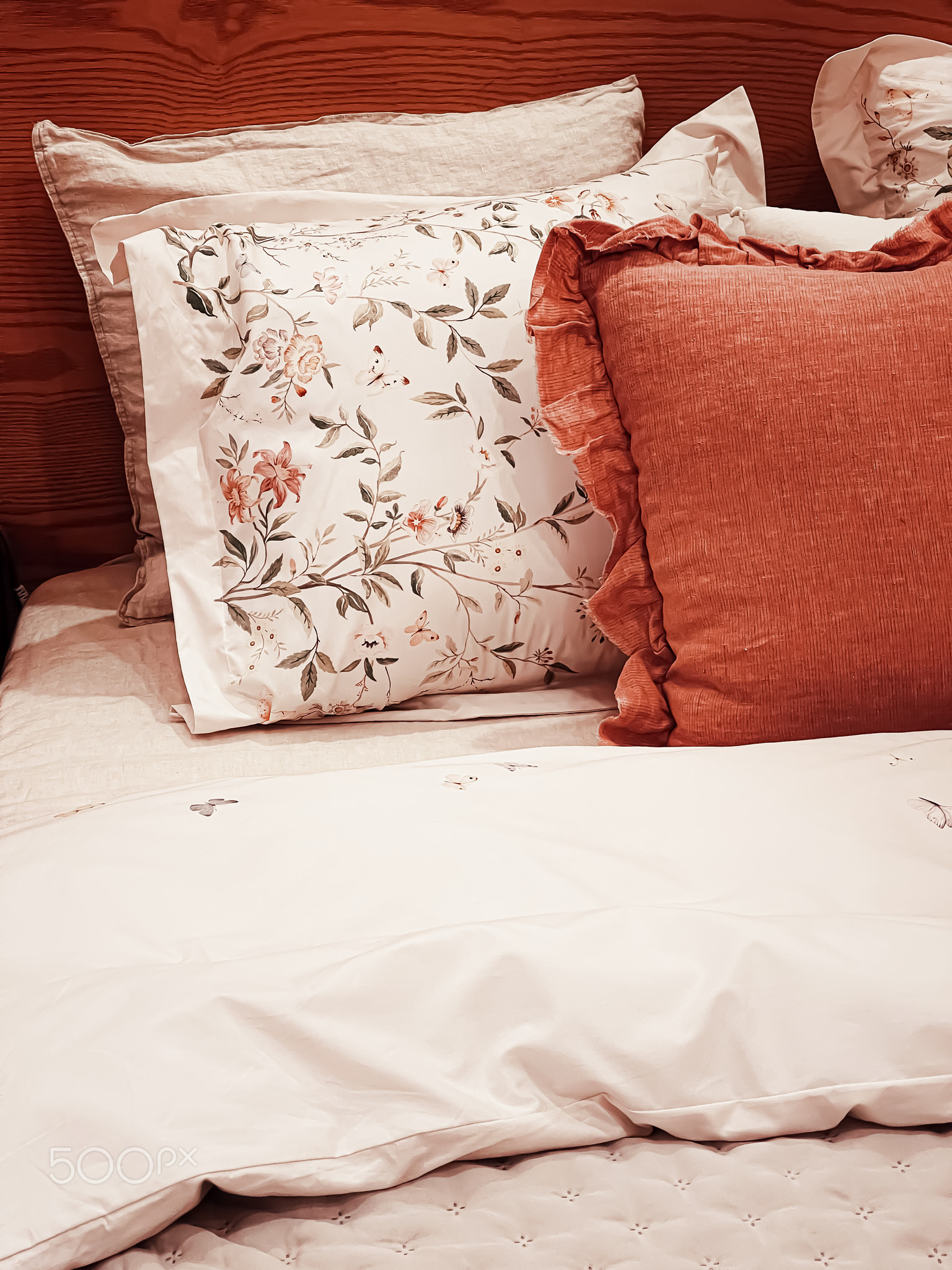 Vintage countryside style bedding with floral pattern on wooden bed in