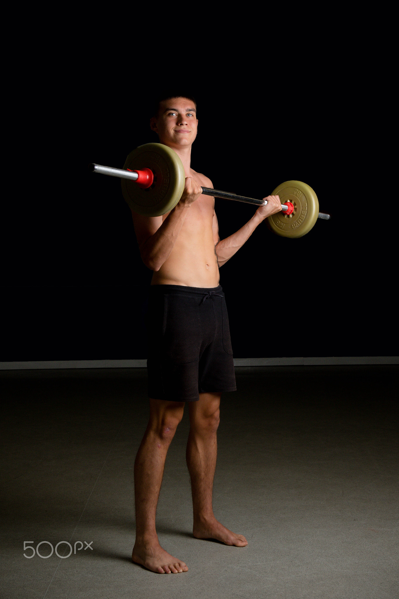 Nineteen year old teen boy  exercising his biceps shirtless