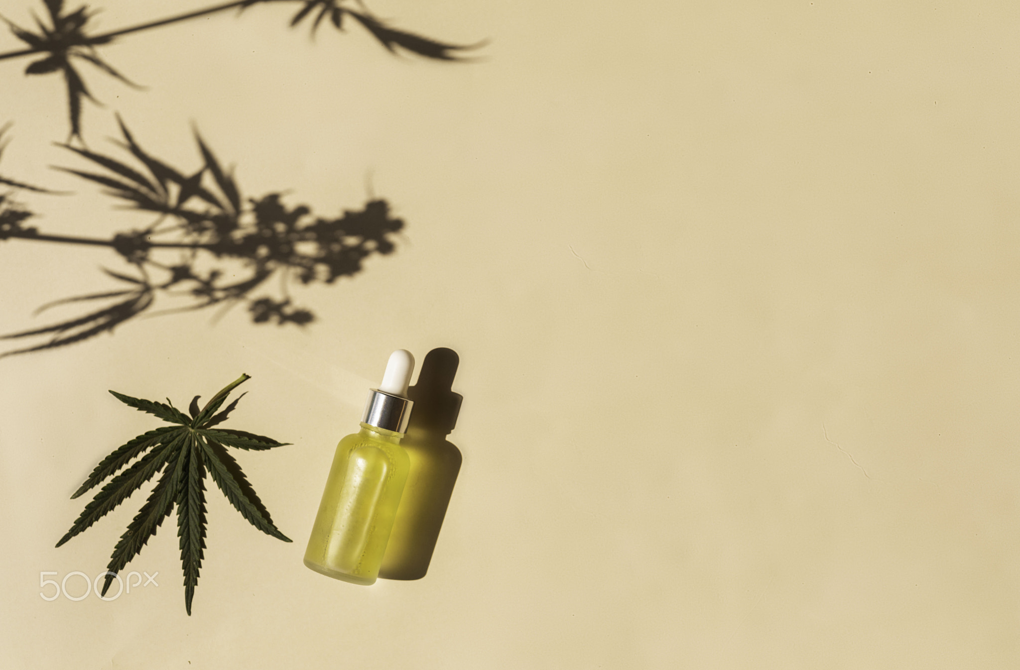 glass bottle with CBD oil, THC tincture on a pastel background with