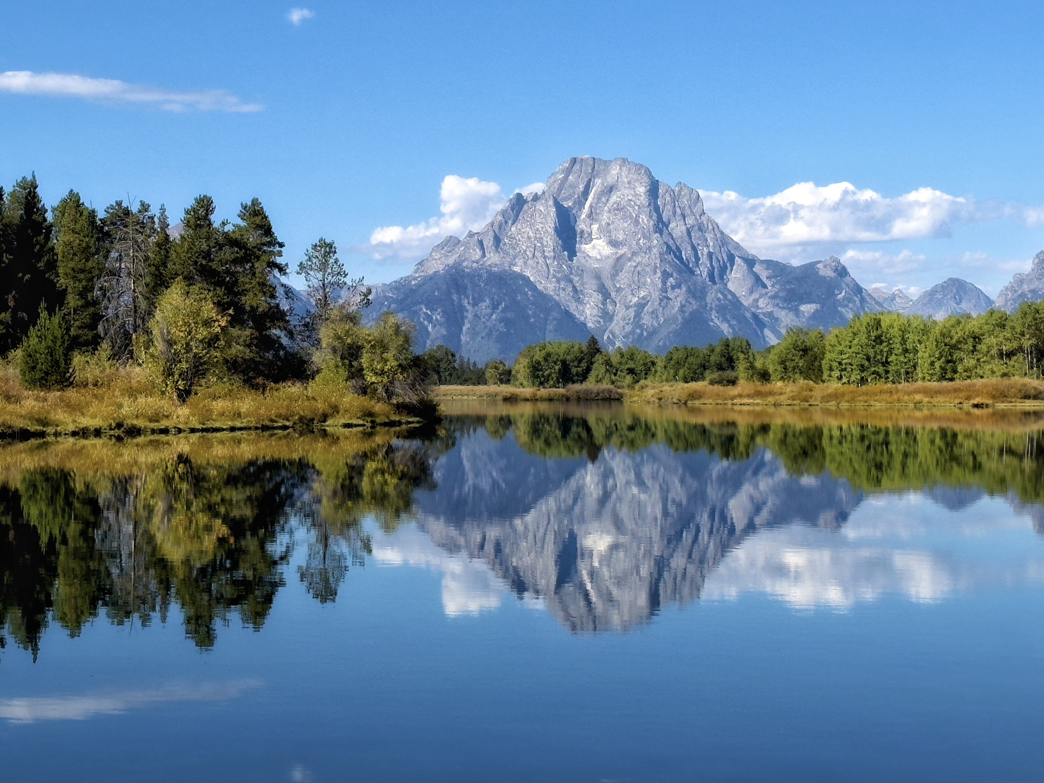 Scenic view of lake and mountains against blue sky by Jeff Clow / 500px