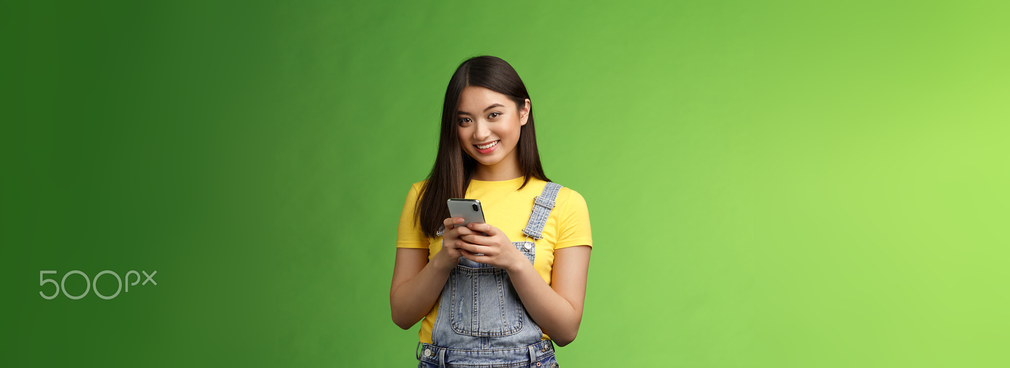 Cute tender asian gorgeous woman using smartphone, smiling carefree
