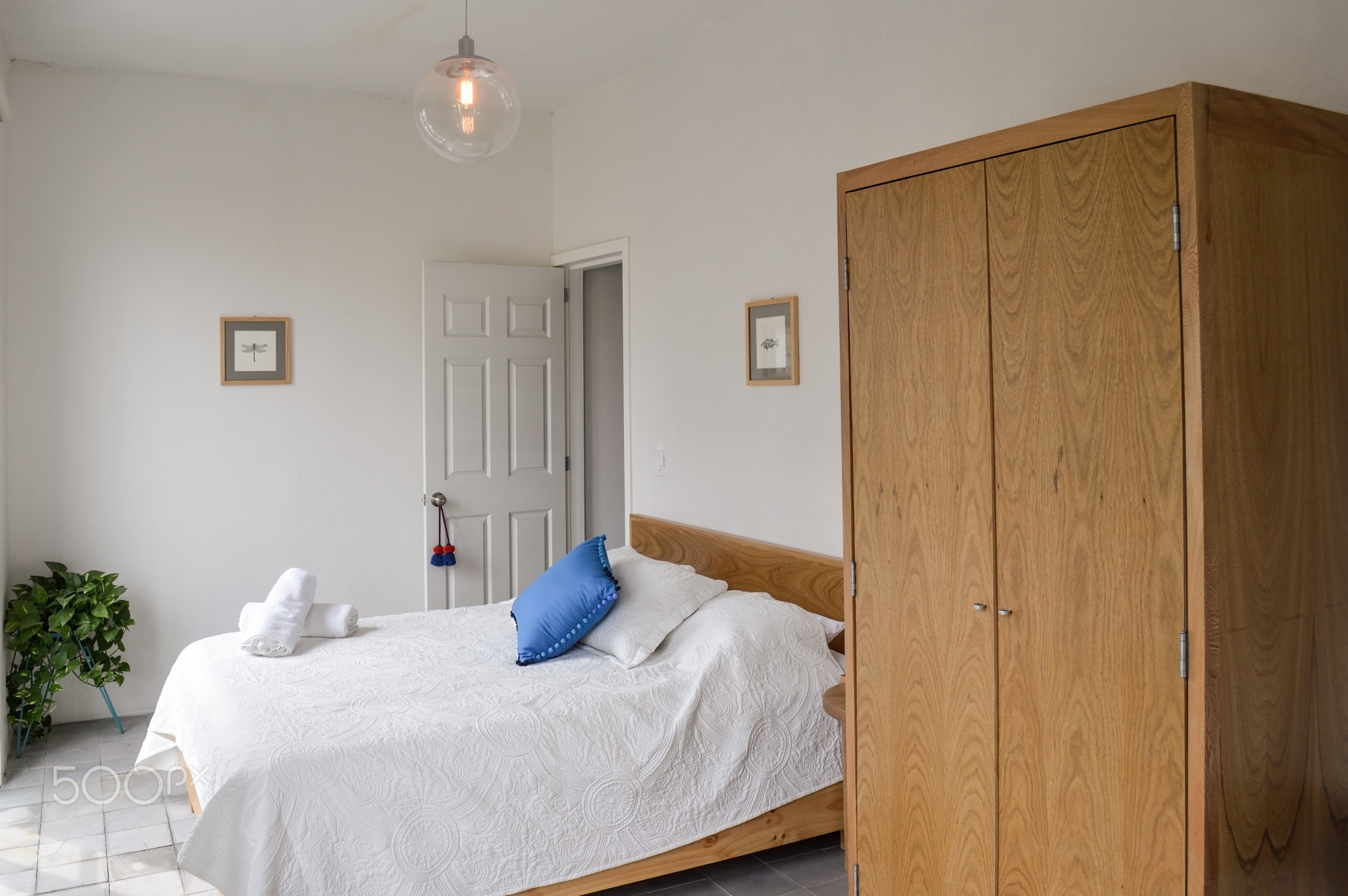 bed base, bedroom with mat on the floor, clay pot in the background