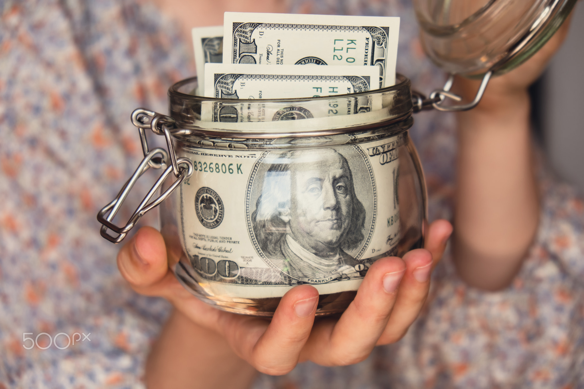 Dollar banknote saving money in glass jar. Unrecognizable woman