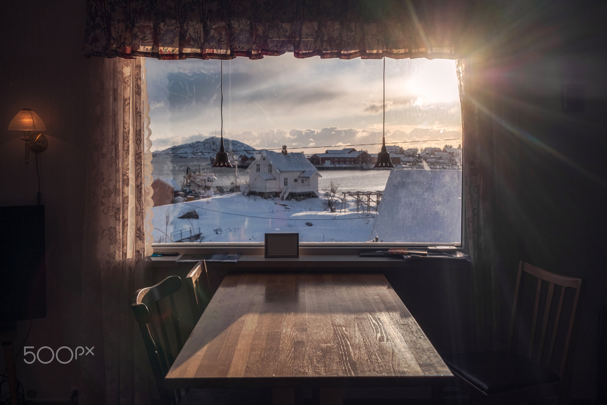 Sunset through on curtain with wooden table