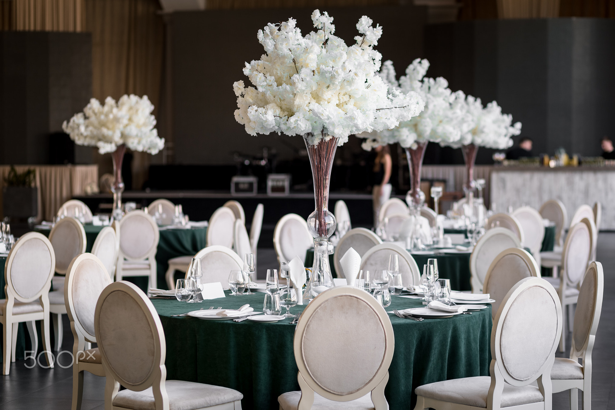 banquet dinner tables with white chairs and white flower bouquet 