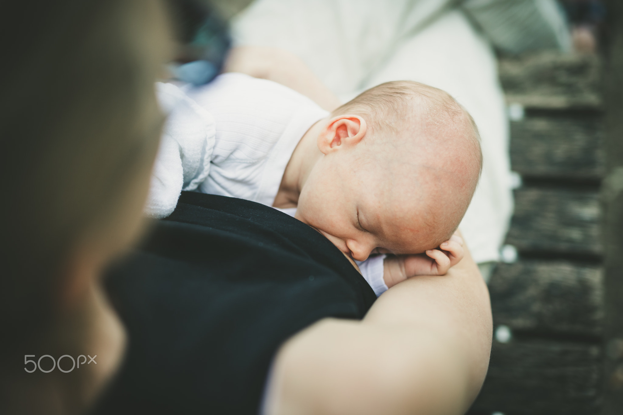 Mother breast feeding and hugging her baby boy outdoors.