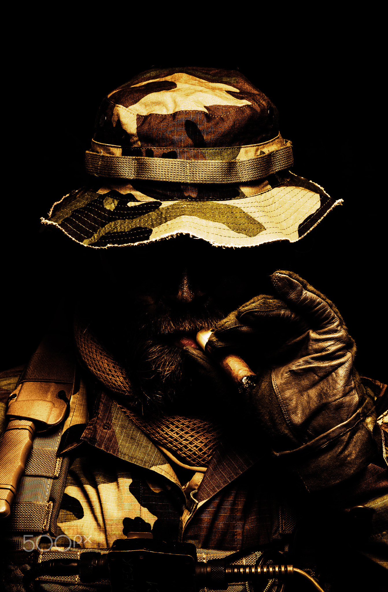 Commando soldier in boonie hat smoking cigar