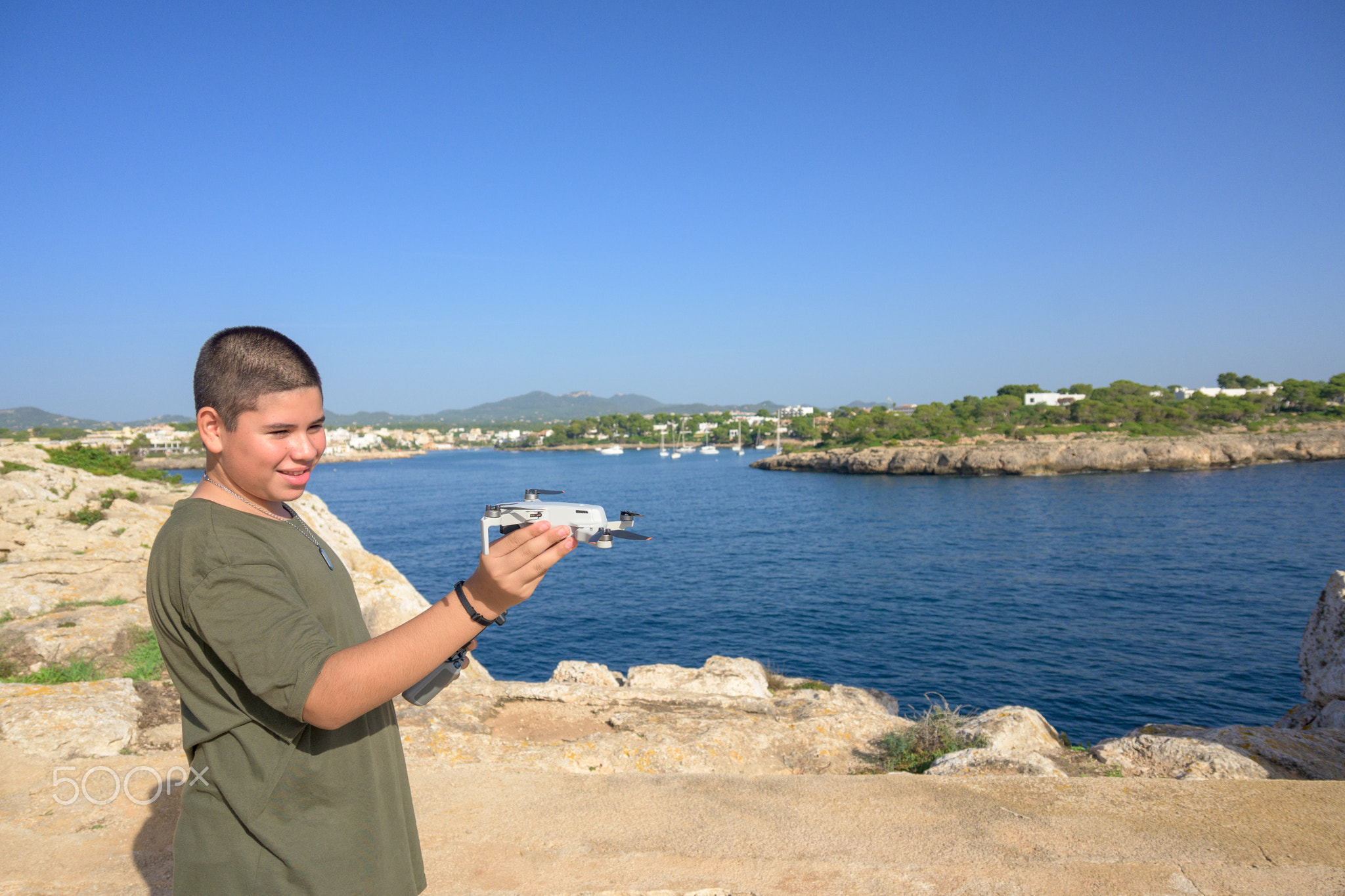 closeup, happy teenage boy, preparing for drone flight during sunny