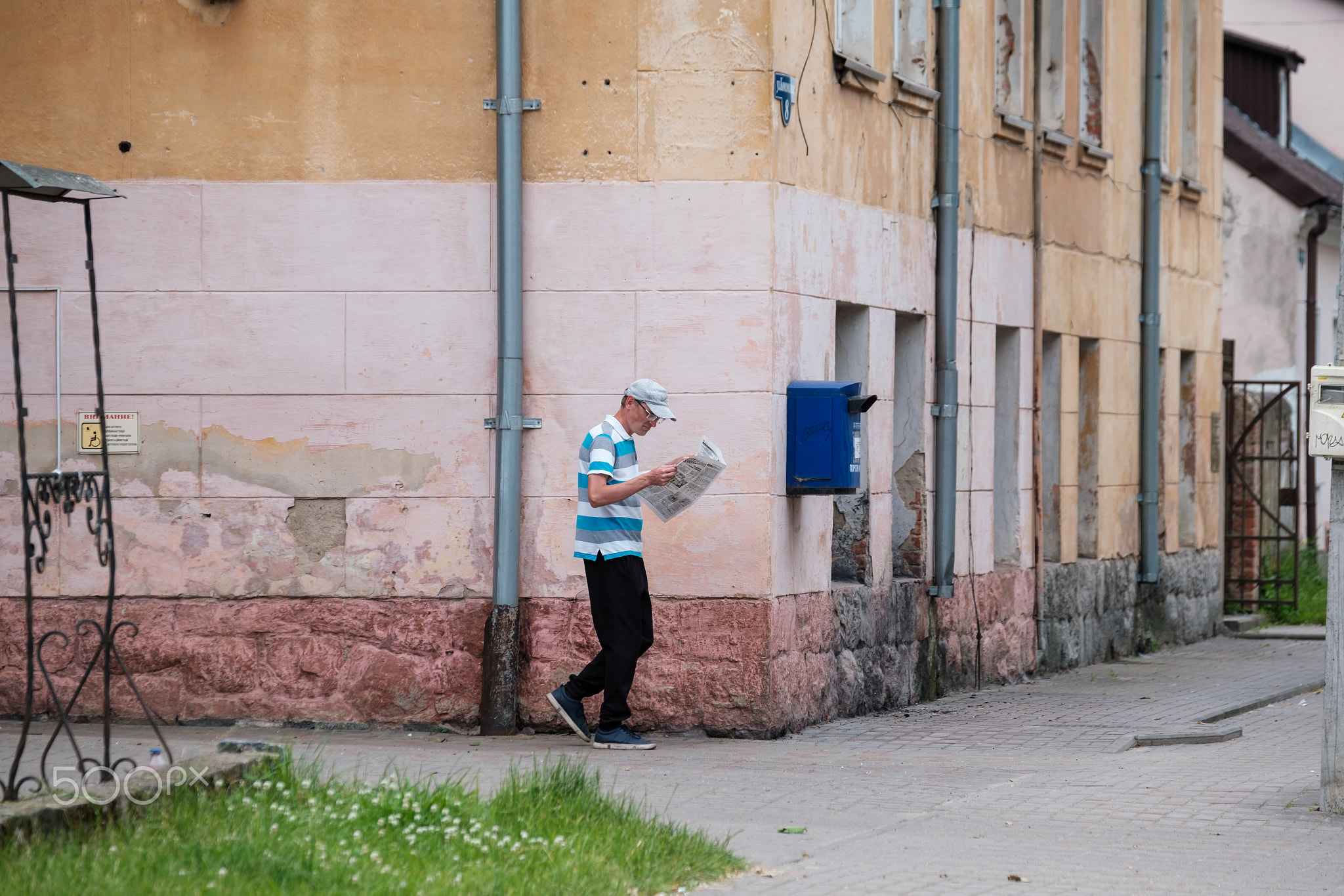 Man walking on street and reading newspaper