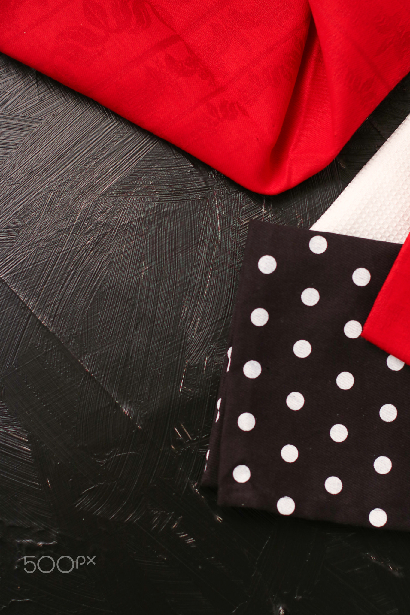 Kitchen textile on black rustic wooden background, napkin and towel