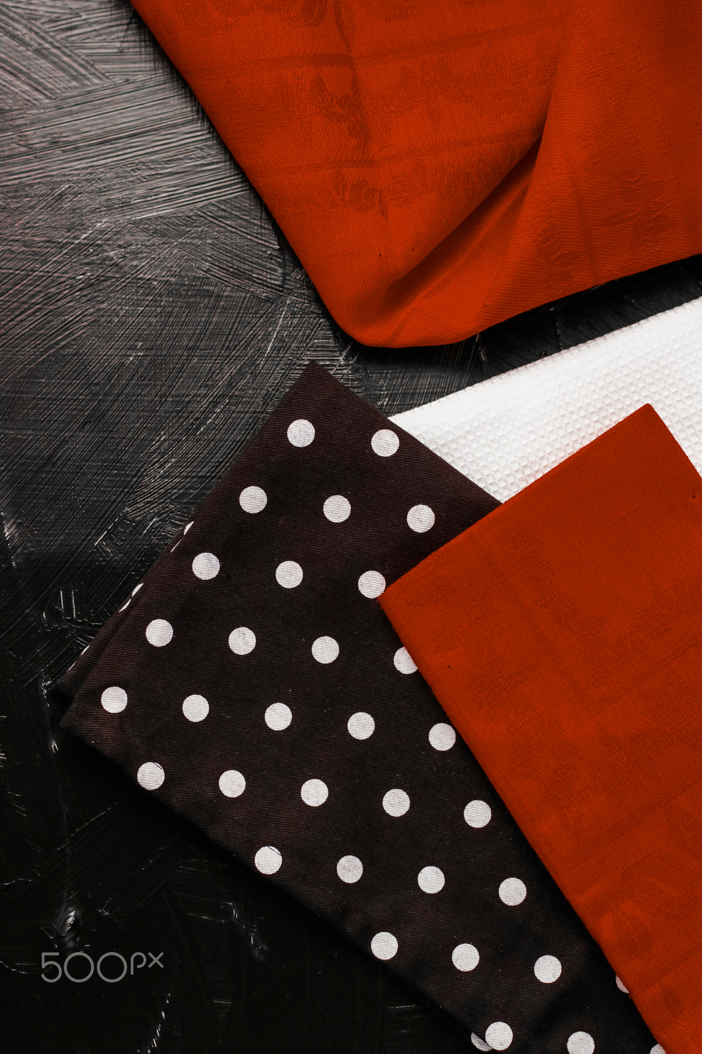 Kitchen textile on black rustic wooden background, napkin and towel
