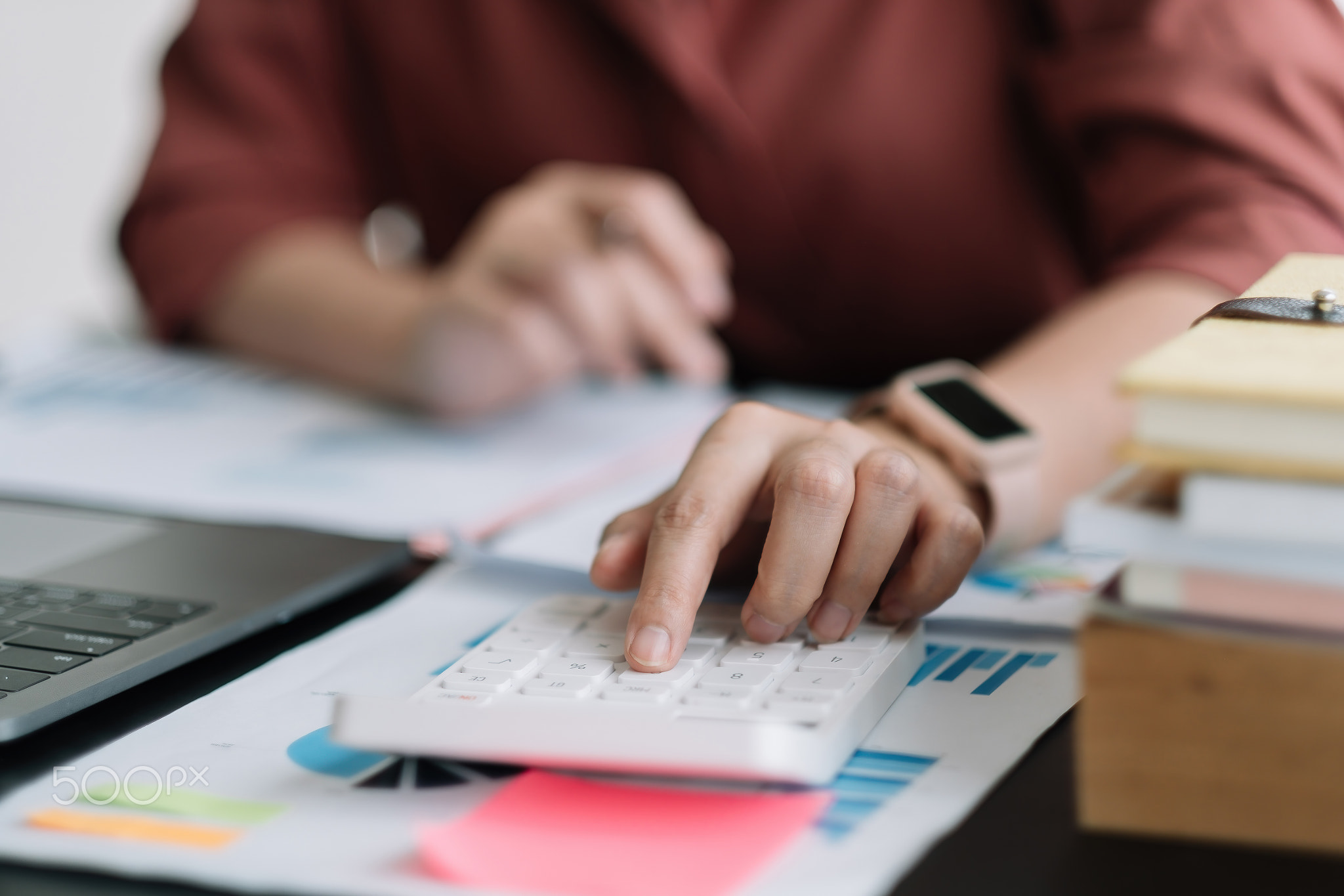 Business woman using calculator for do math finance on wooden desk in