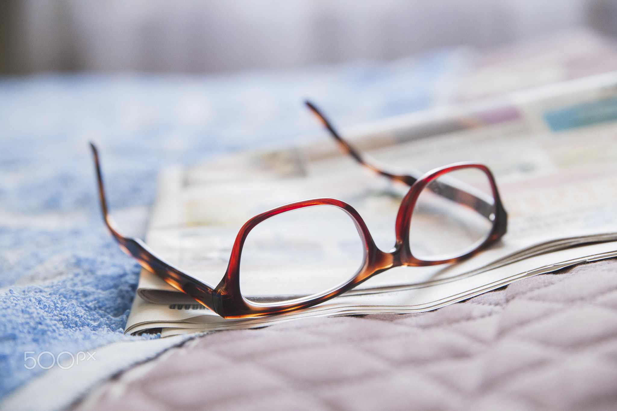 old fashioned glasses lie on the newspaper in the bedroom