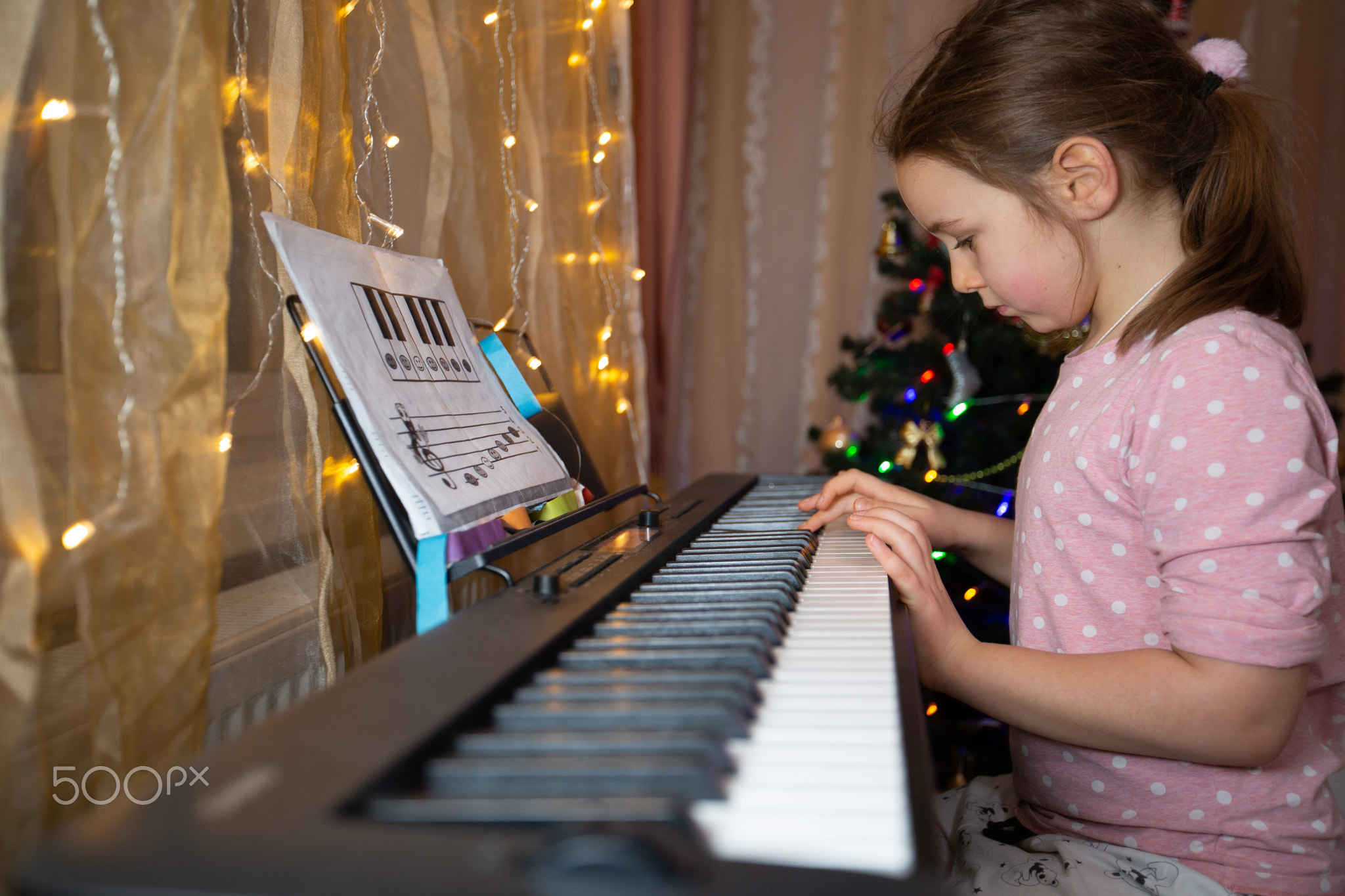 A school-age girl is engaged in music lessons