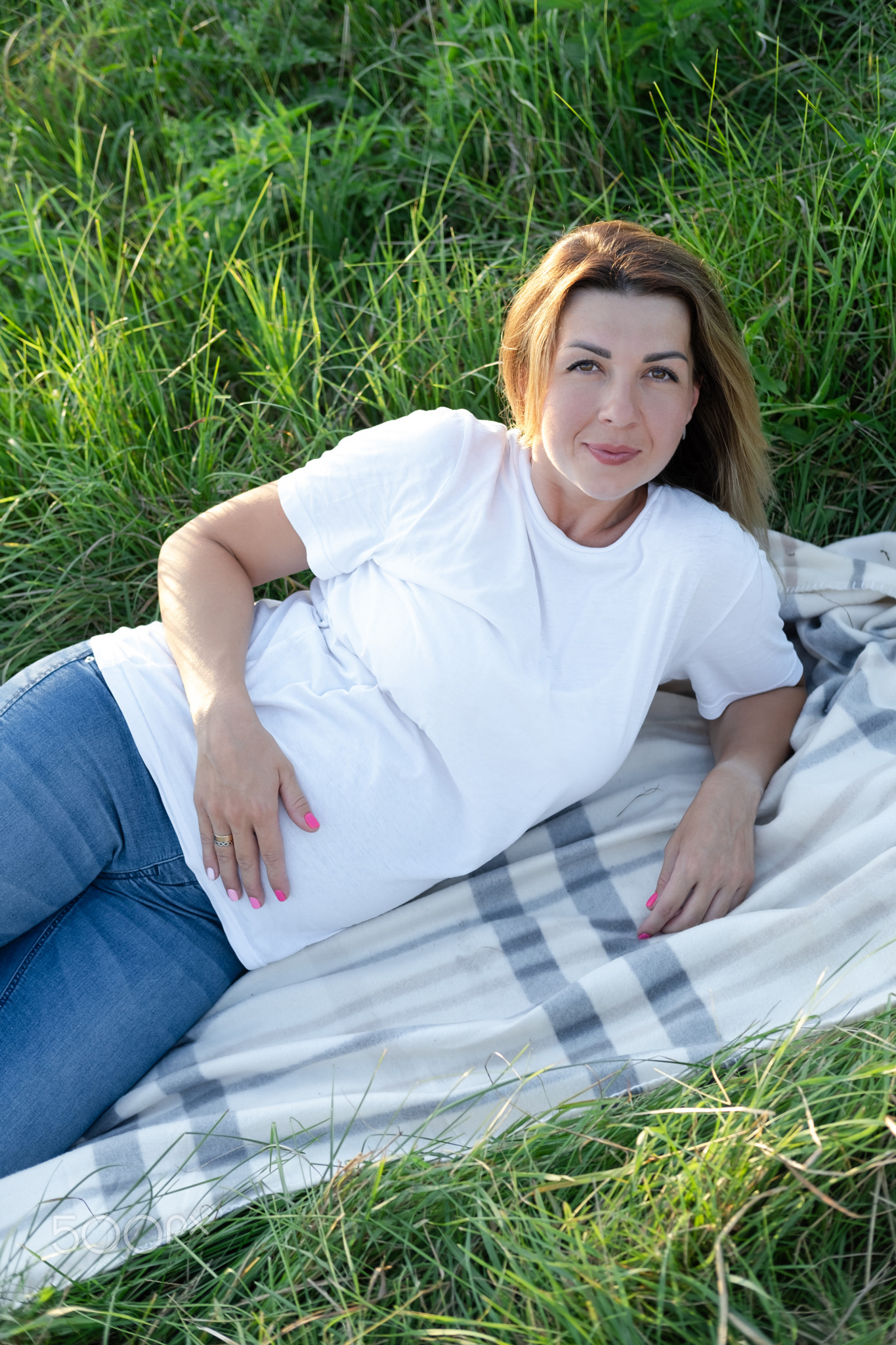 cute pregnancy portrait. happy mother to be with a big belly in white