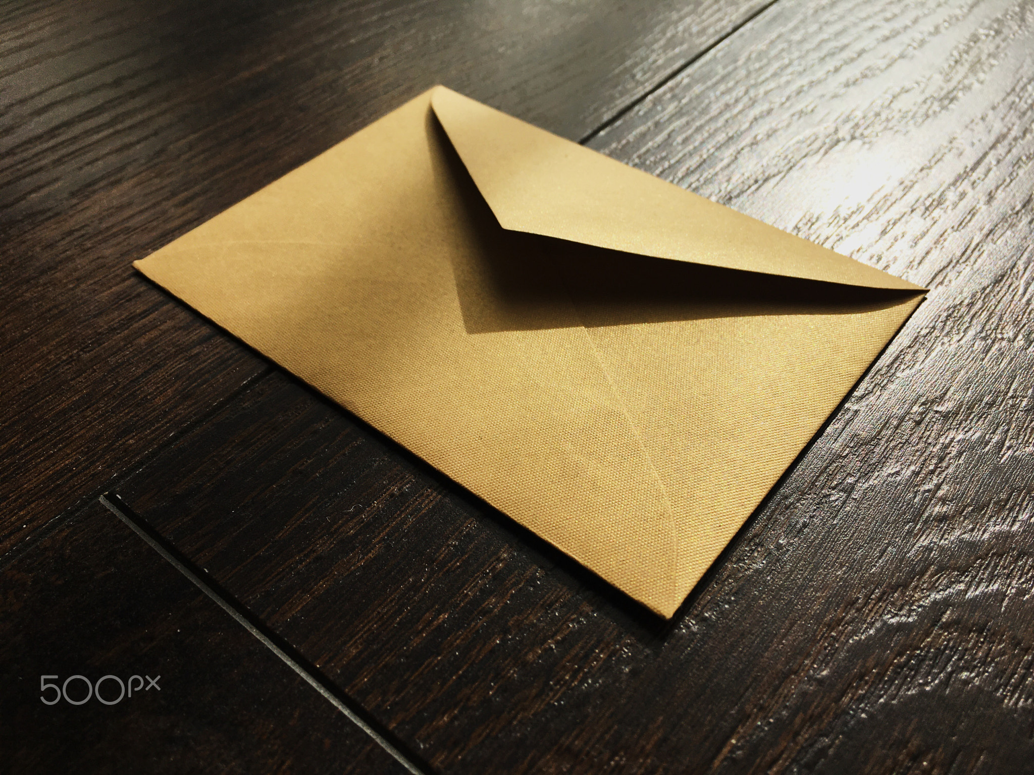 Golden envelope on wooden background, news and communication