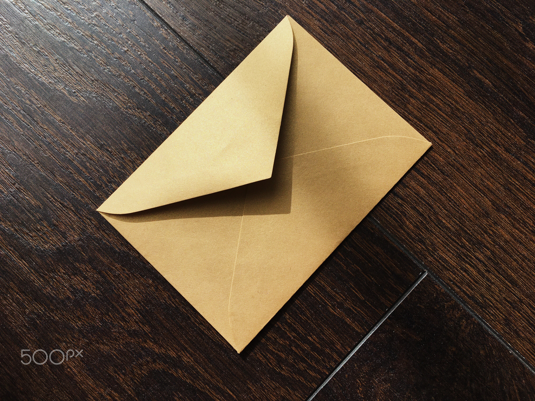 Golden envelope on wooden background, news and communication