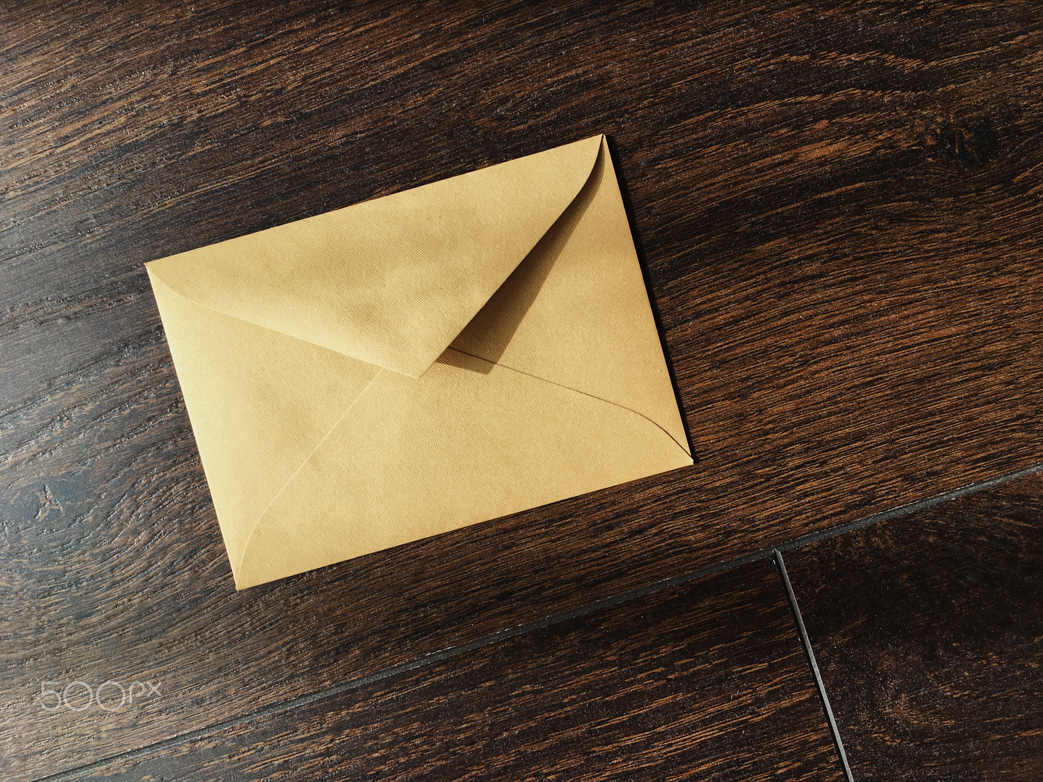 Golden envelope on wooden background, news and communication