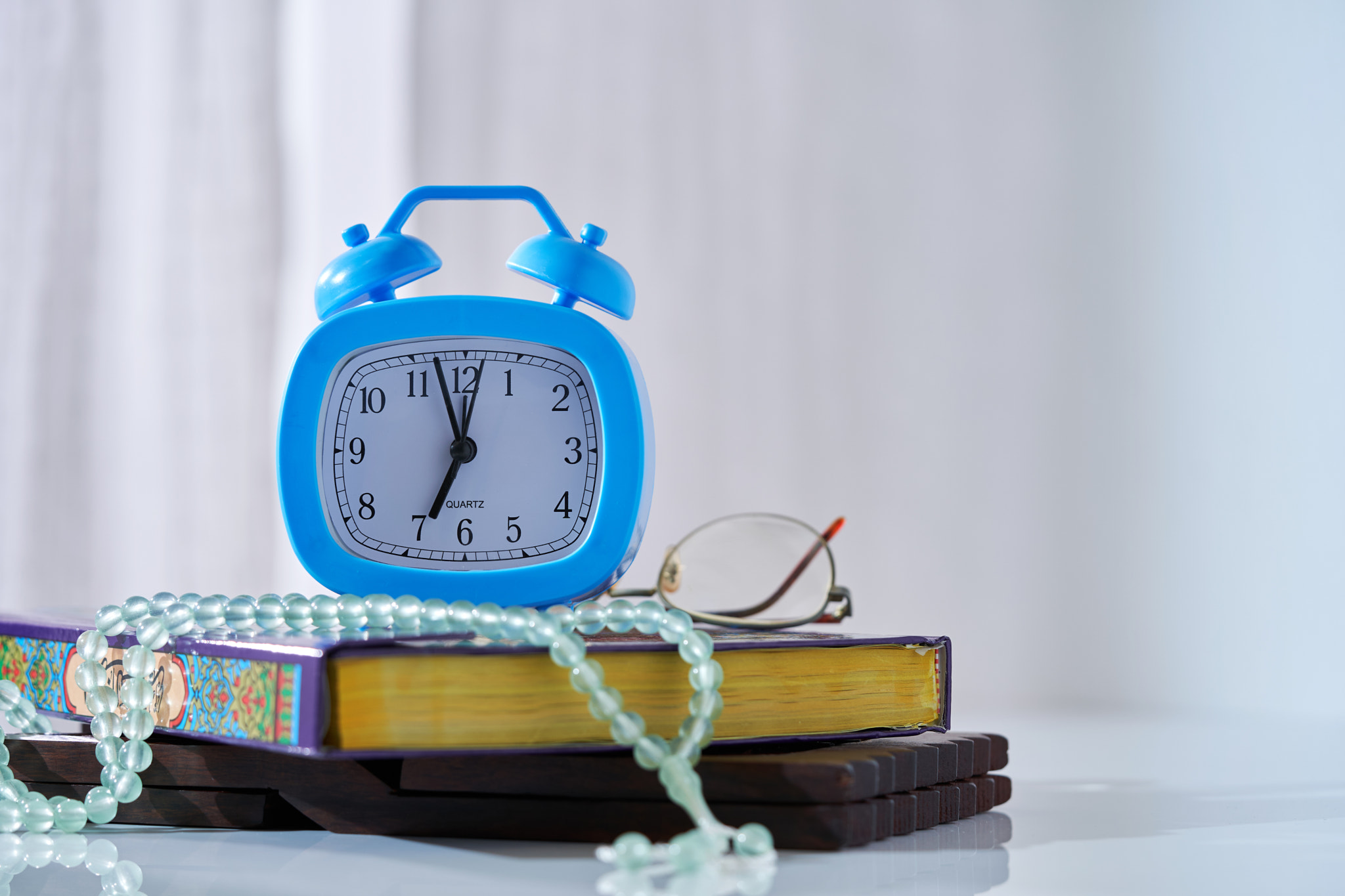 time for prayer, alarm clock koran and prayer beads     