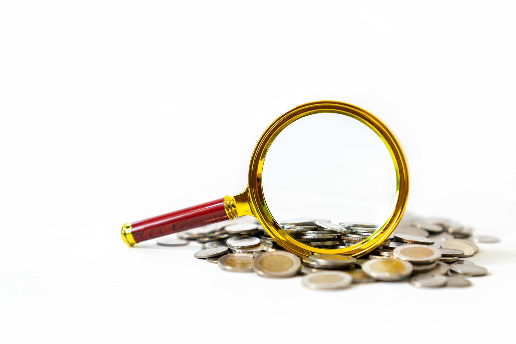 Inspecting money coins isolate on white background.