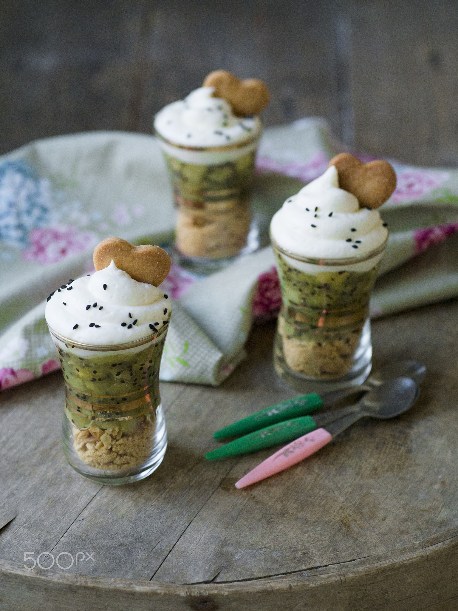 dessert in a glass with kiwi sauce, white butter cream, decorated with