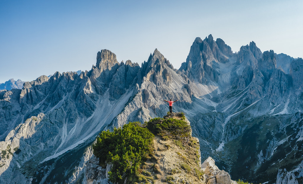 Aerial view of a man with raised hands on the top edge admiring epic by Igor Tichonow on 500px.com