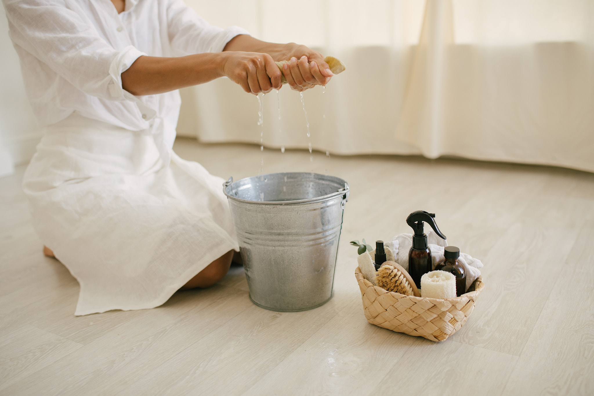 Young woman cleaning room using natural wooden brush. Sustainable eco friendly tools for cleaning.