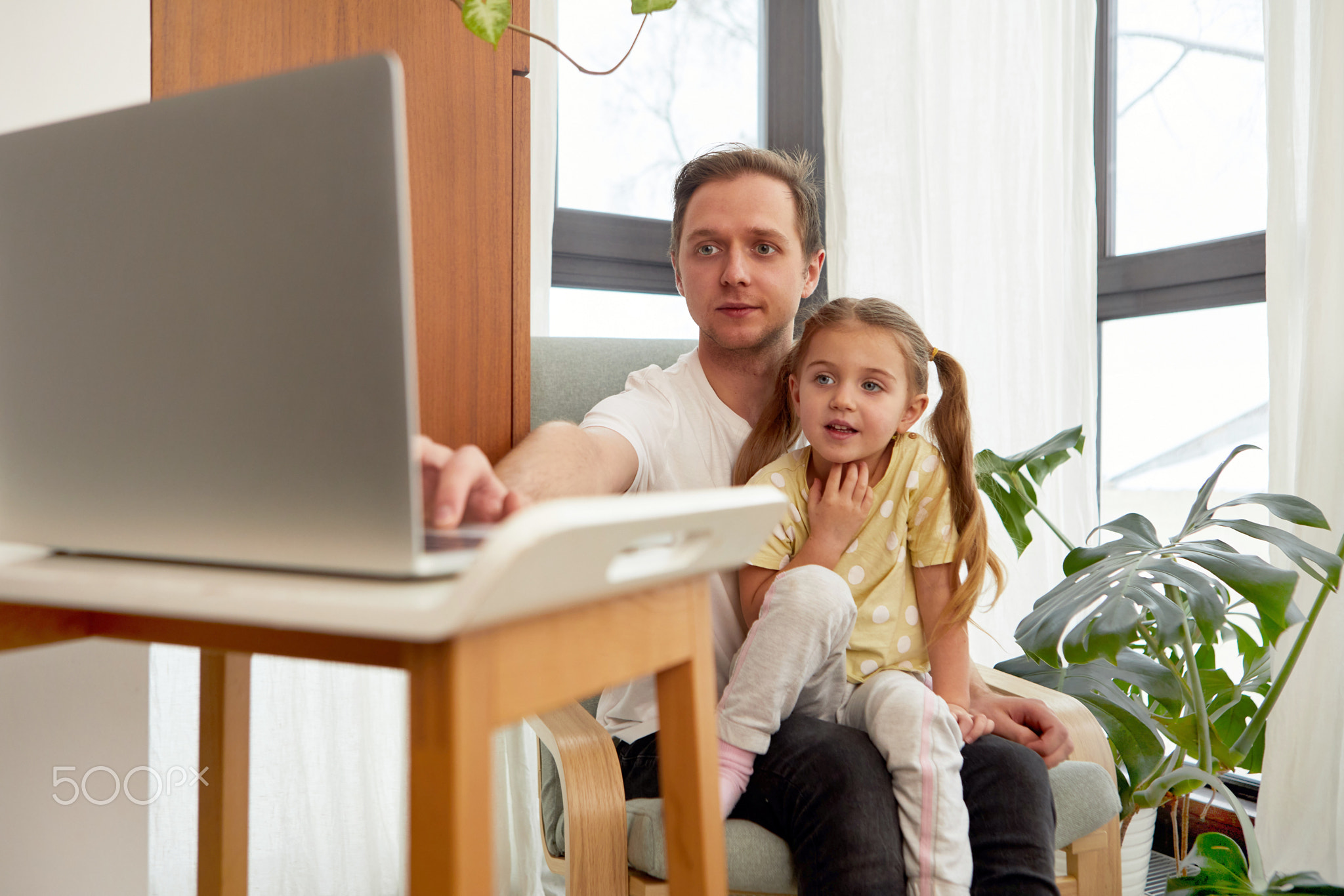 Father and daughter use laptop at home