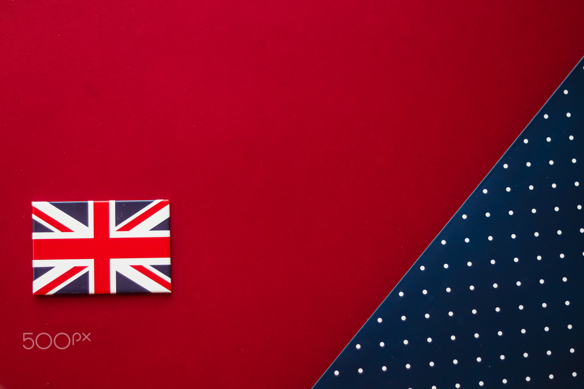 British flag on red and blue polka dot flatlay background as abstract