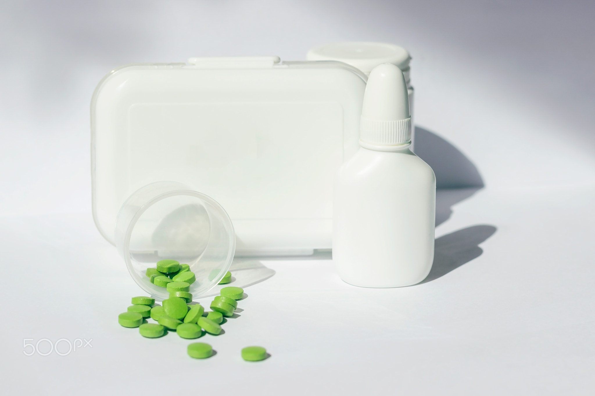 A small first aid kit with pills. There are jars of medicines nearby