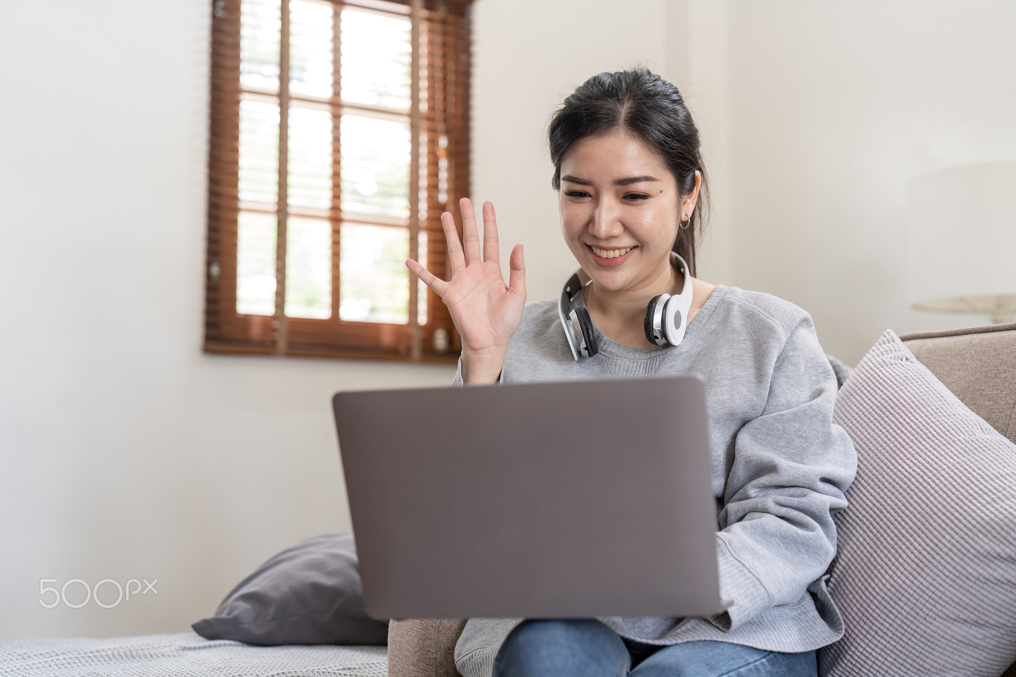 Friendly woman waving her hand in online meeting