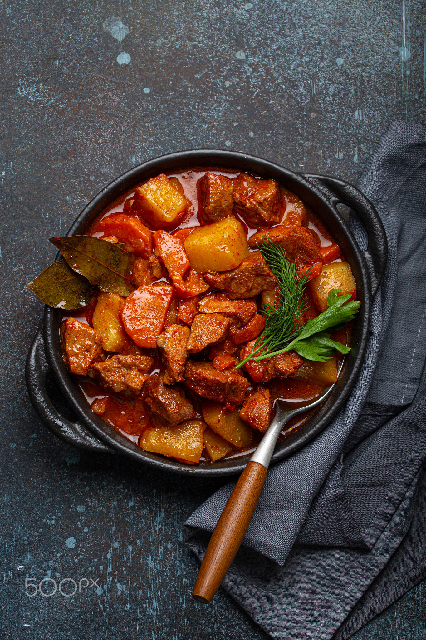 Beef meat stew with potatoes, carrot and delicious gravy in black