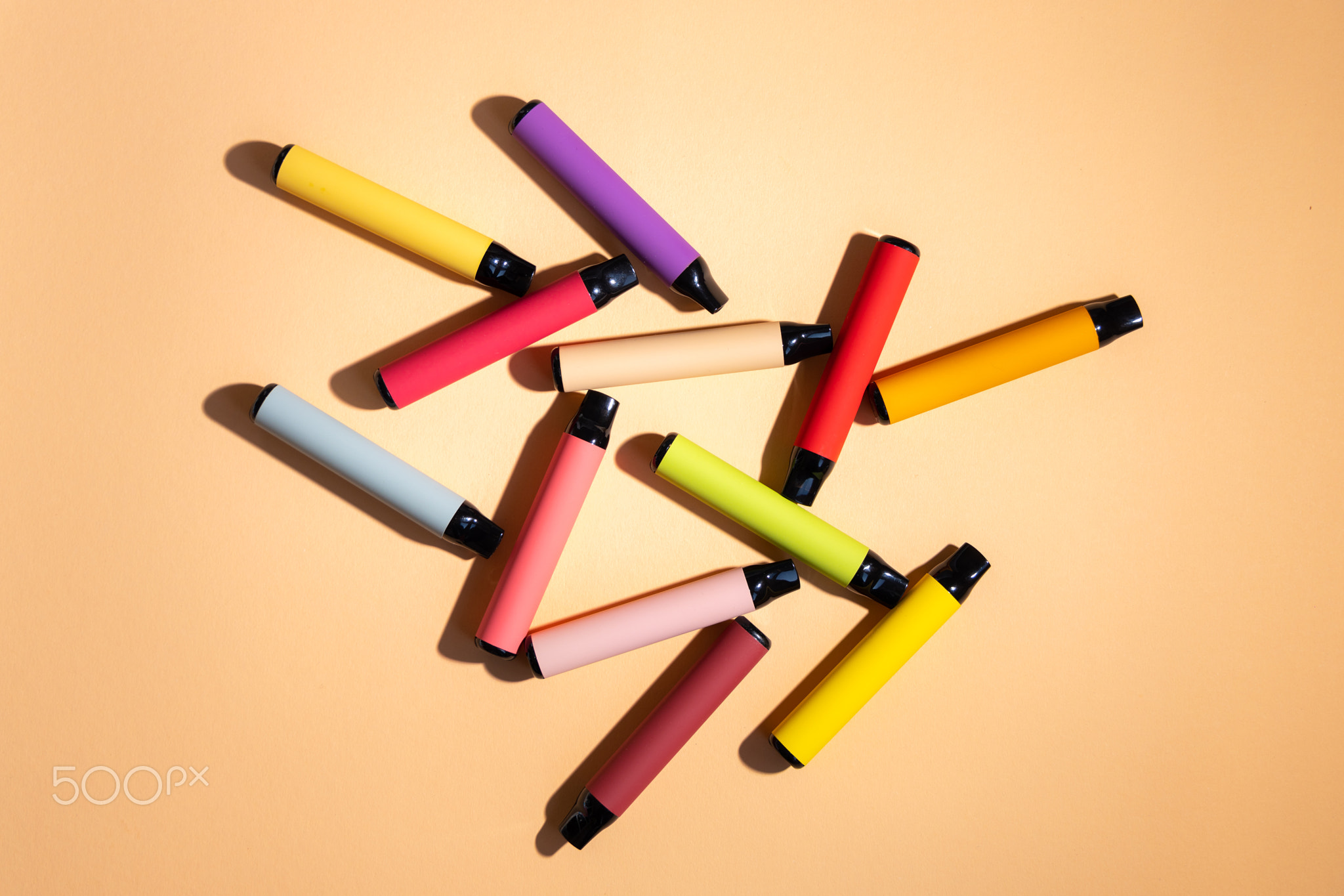 Layout of colorful disposable vapor stick on a light background