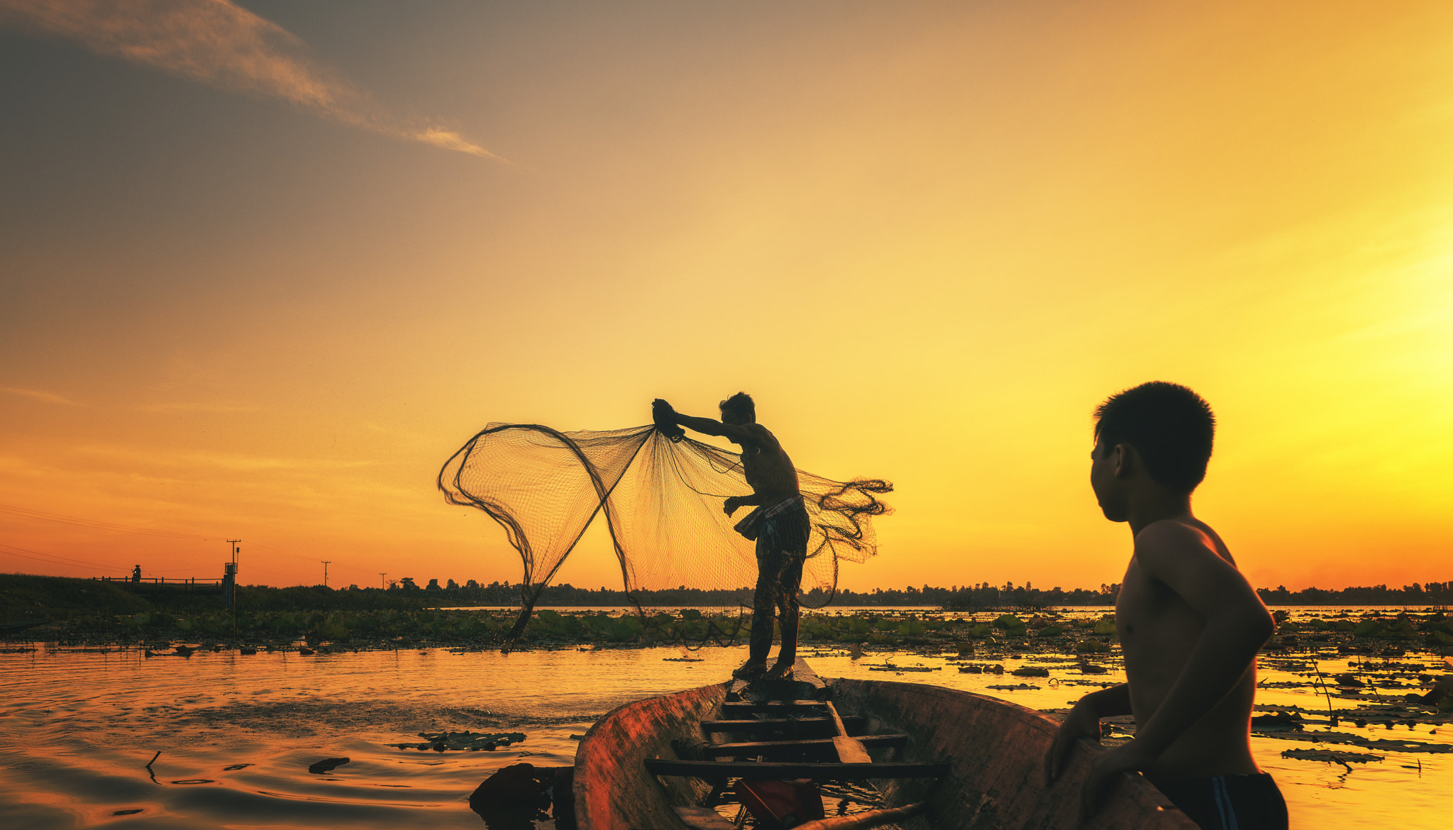 Boys fishing at the river by Sasin Tipchai