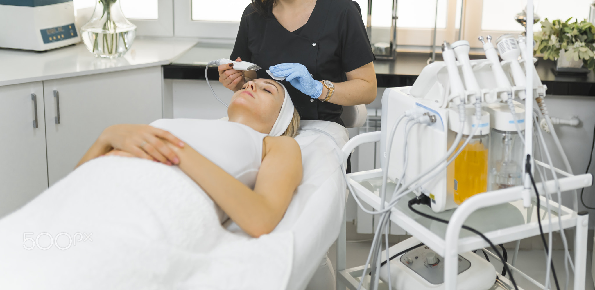 Medium shot of a beautician doing microdermabrasion treatment on a