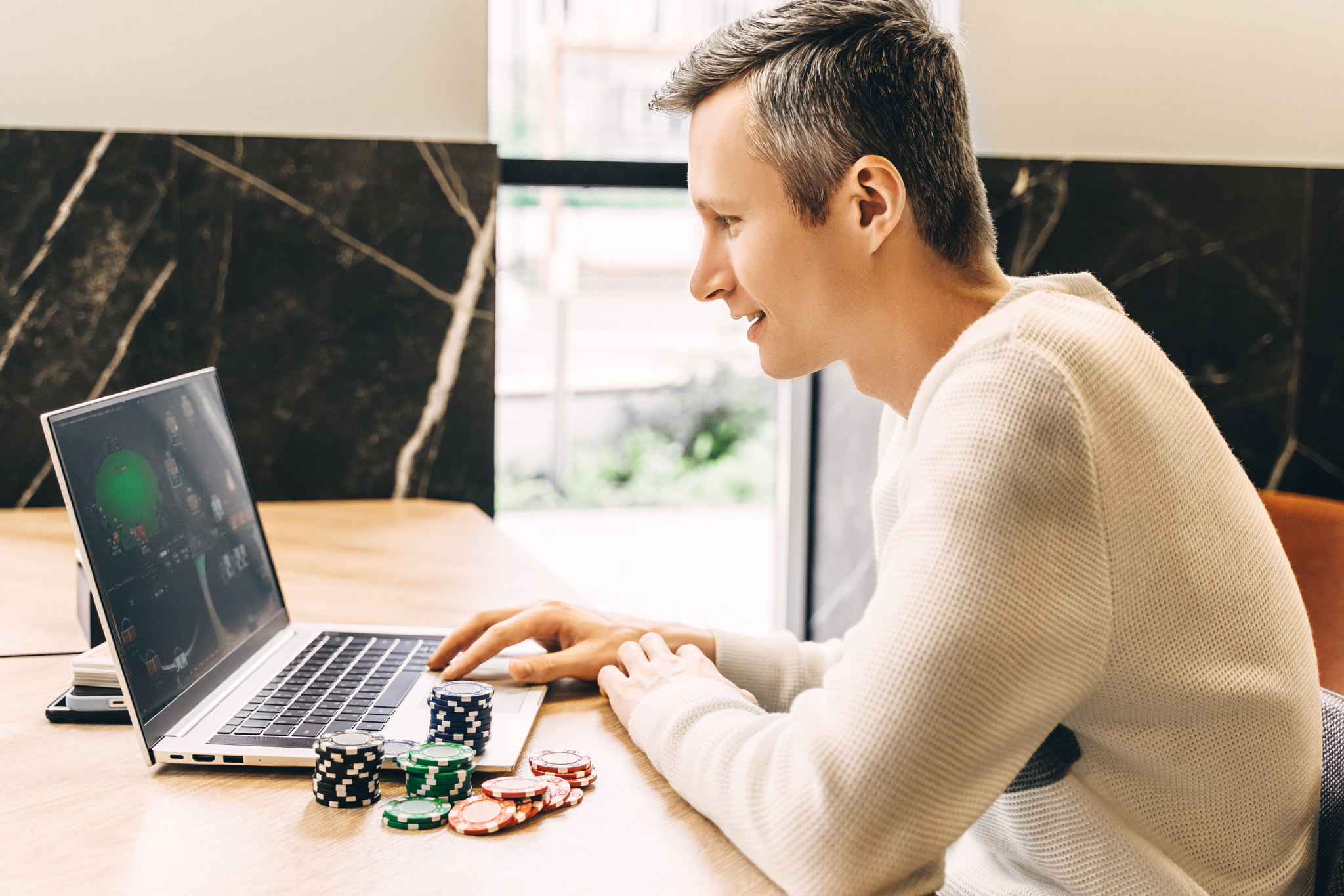 Young man play online poker in laptop.