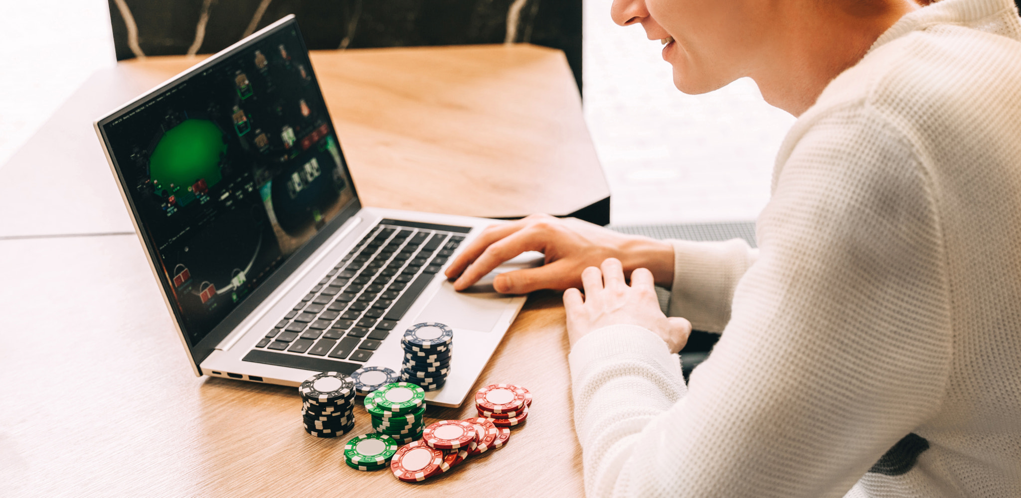 Young man play online poker in laptop.