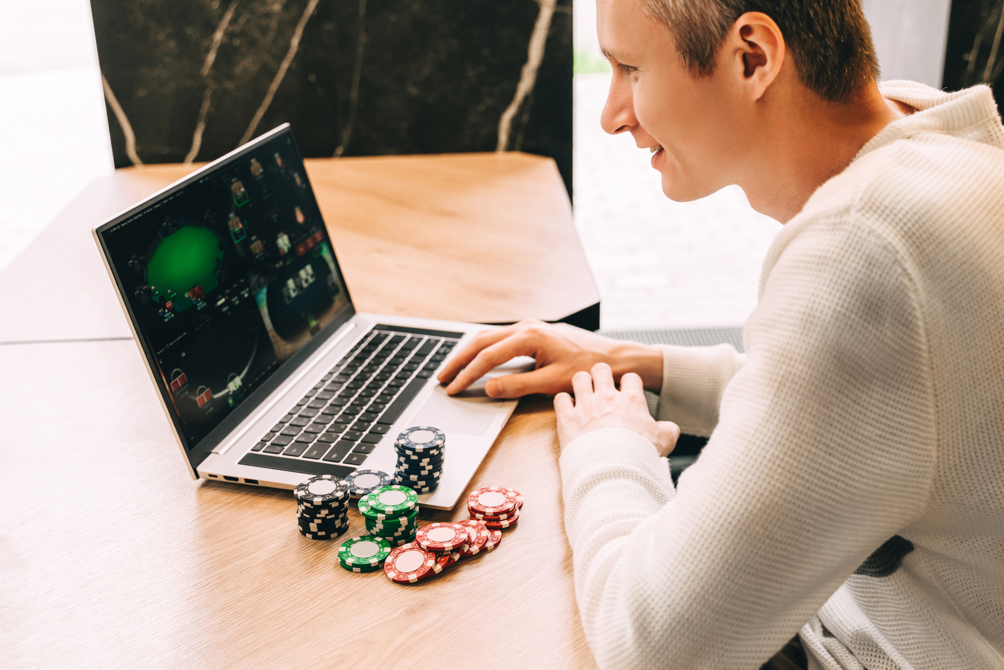 Young man play online poker in laptop.