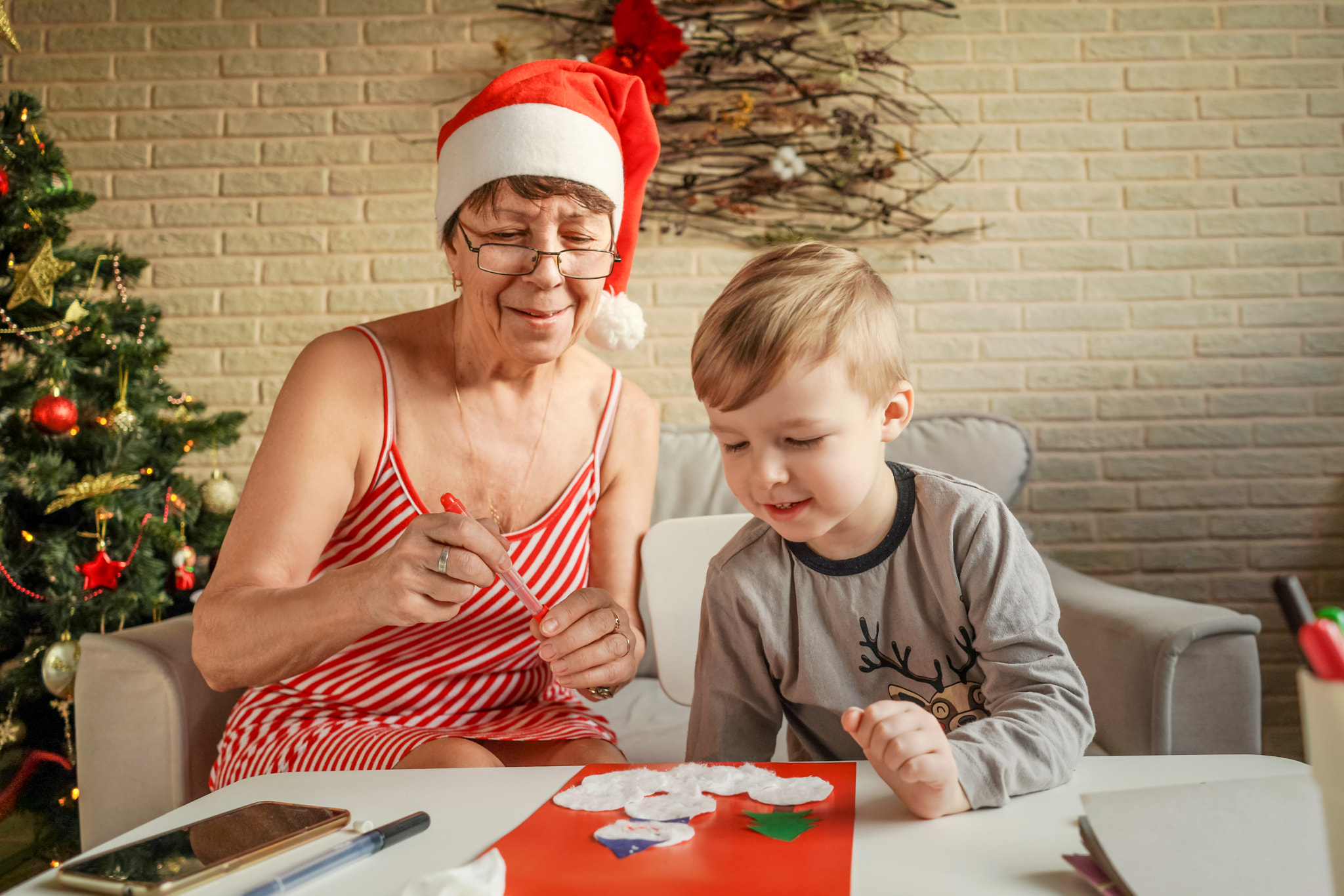 A Little boy with grandmom make greeting card.