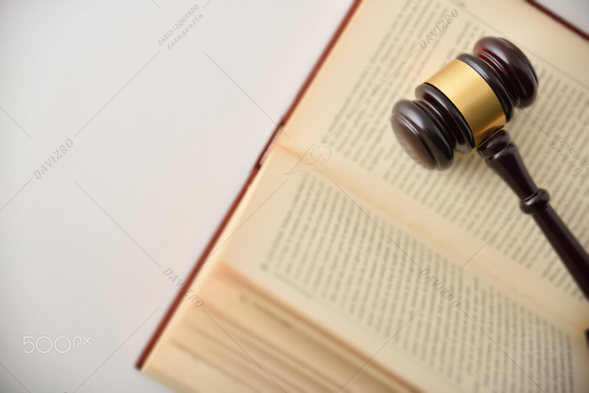 Gavel on open law book on white table top view