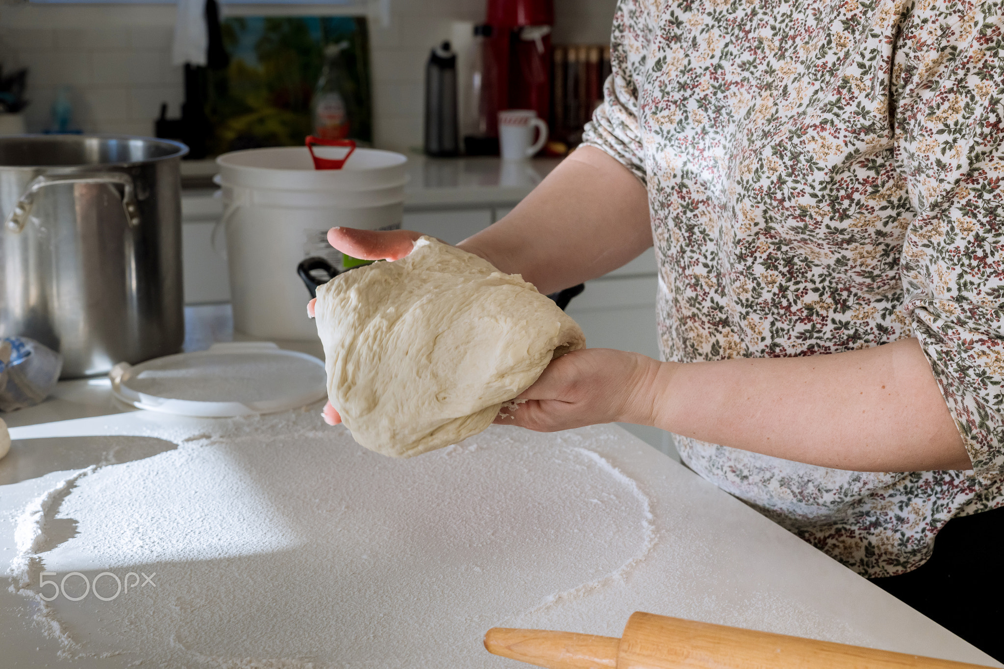 Woman mixing yeast dough for making homemade donuts.