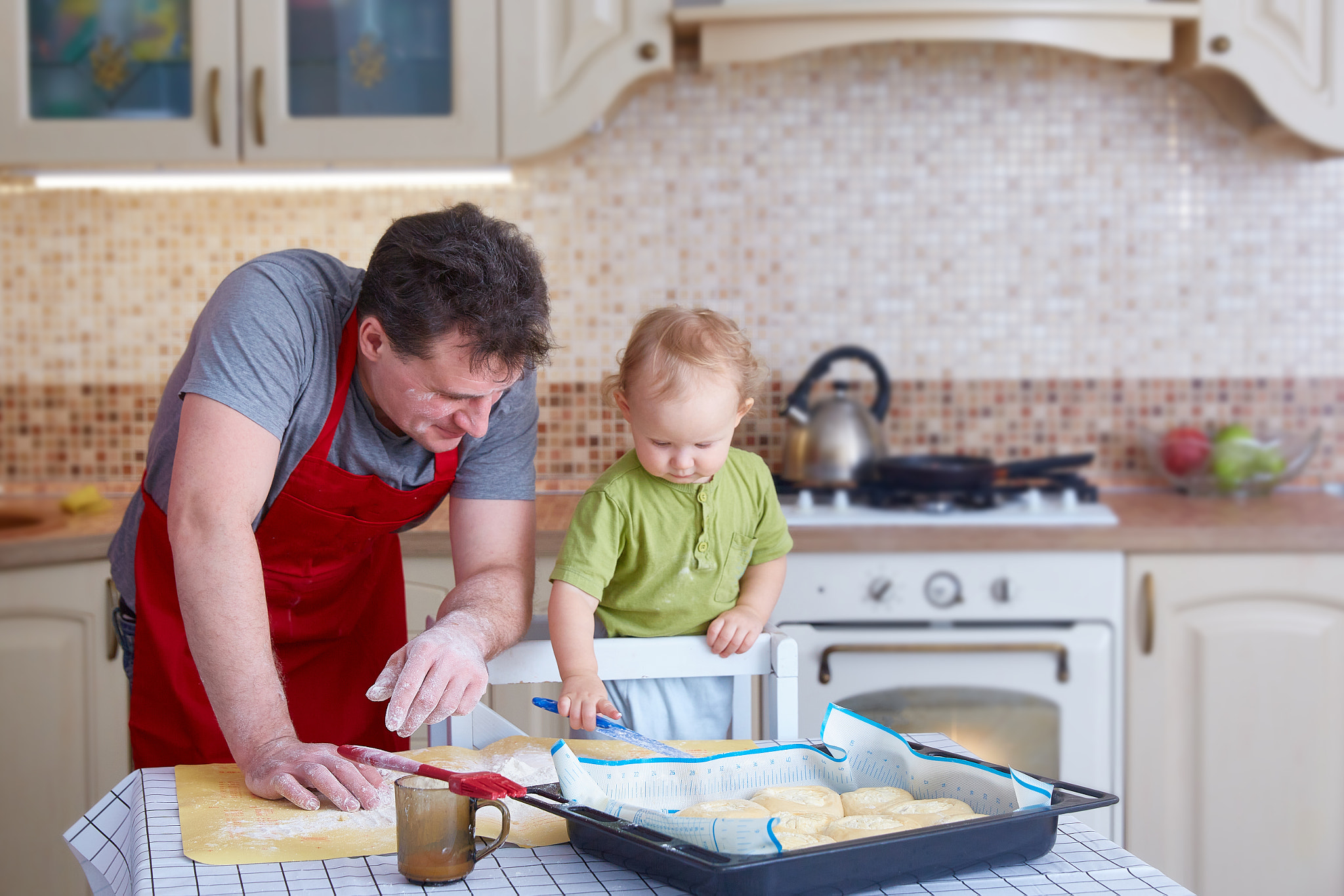 Dad and a small child cook together in the kitchen. The concept of family and mutual understanding.