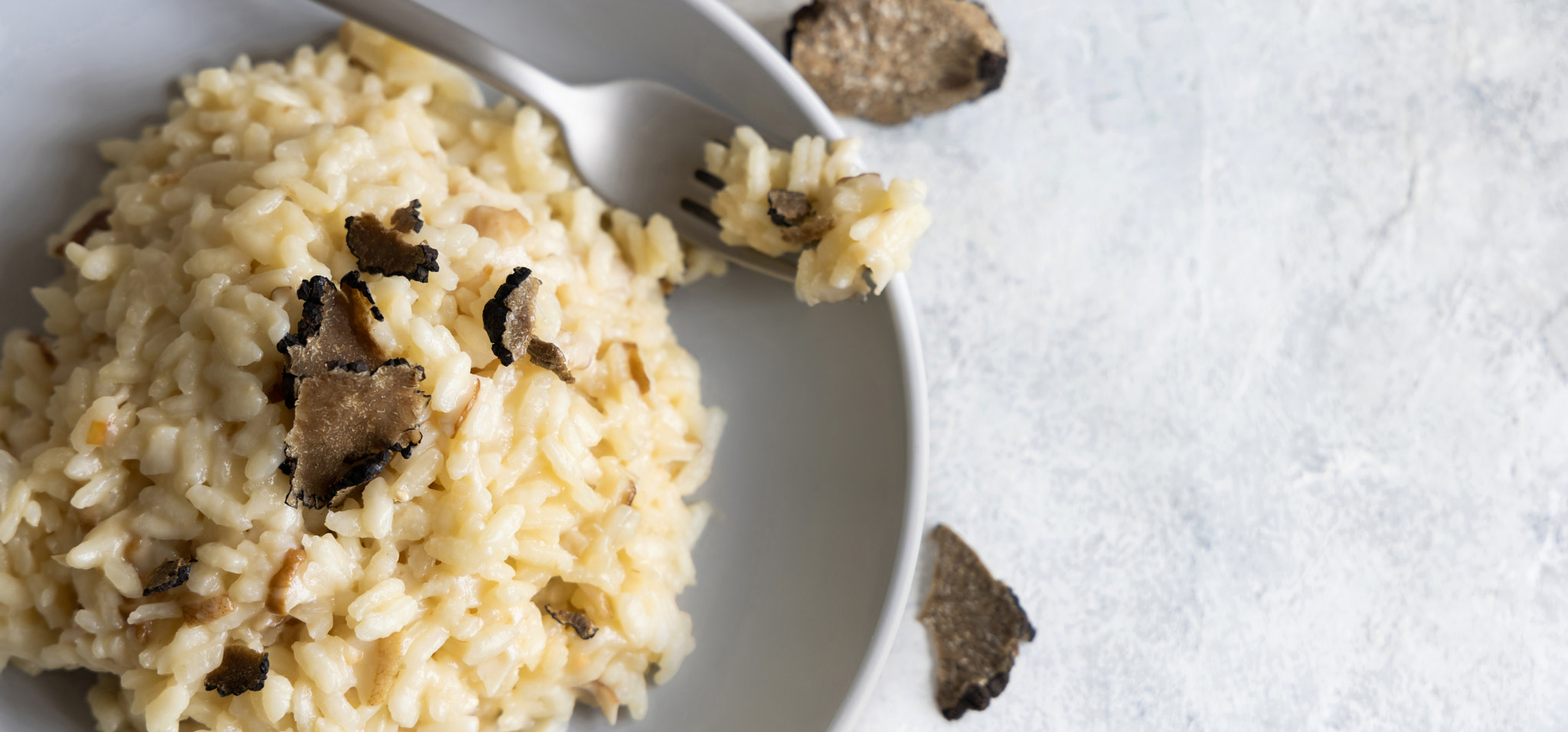 Risotto with porcini mushrooms and black truffles served in a plate top view, gourmet cousine