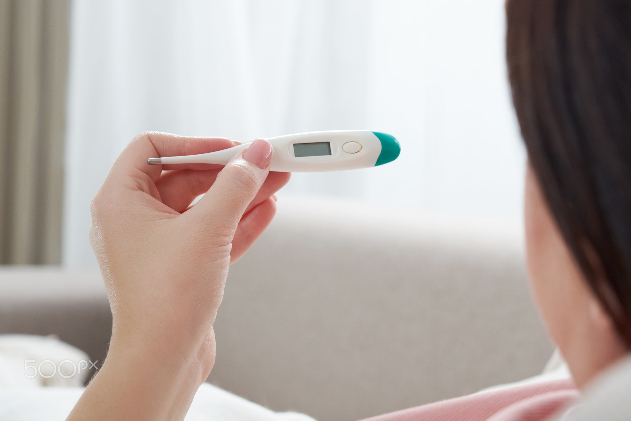 Woman holding a digital thermometer. Concept of fever, flue, virus and