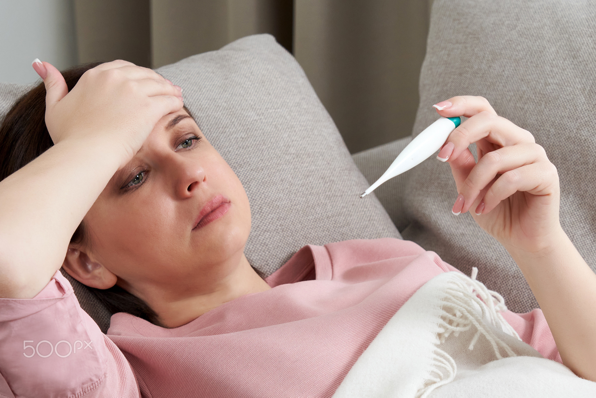 Woman holding a digital thermometer. Concept of fever, flue, virus and